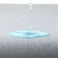 Person spilling liquid on Encase HD mattress protector to show its protective capability. - Mattress King