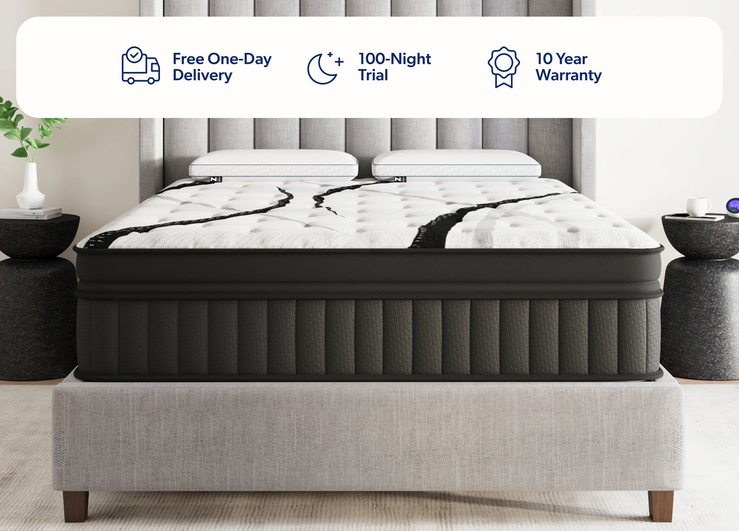 A bed with a white tufted mattress featuring black marble-look veining, set against a gray upholstered headboard and footboard. Two dark side tables with vases sit on either side.