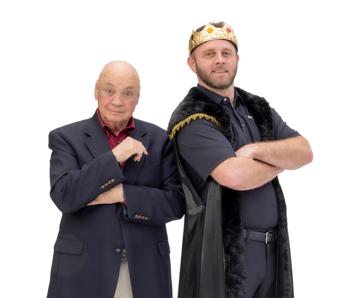 Two men, one in formal attire and the other in a king's outfit with a crown, standing against a white background.
