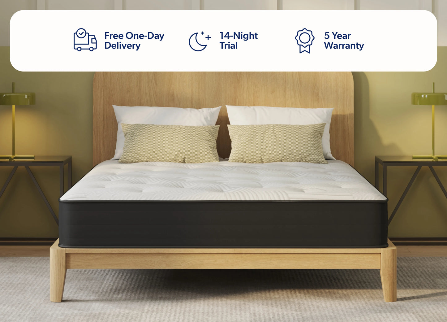 A bed with a white quilted mattress and a black side panel, set against a light wood headboard and frame. The bed is styled with two beige pillows and is flanked by matching bedside tables with lamps.