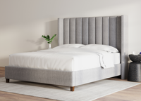 Front angle view of the Blackwell Bed in stone, showcasing its plush padded channels and wingback design - Mattress King